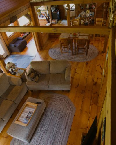 Interior of a log home living room seen from the loft above