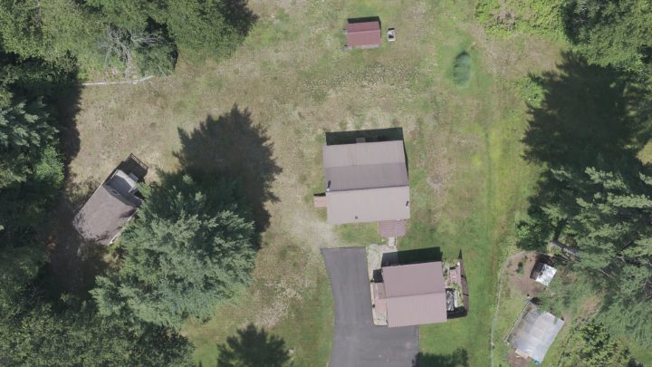 Top-down aerial view of a rural property, house and outbuildings